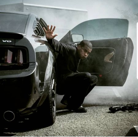 Cory Hardrict poses for a picture in a car in the wallpaper of The Oath.